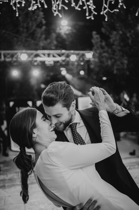 Pareja bailando románticamente bajo luces en un evento. Atmosfera festiva y elegante.